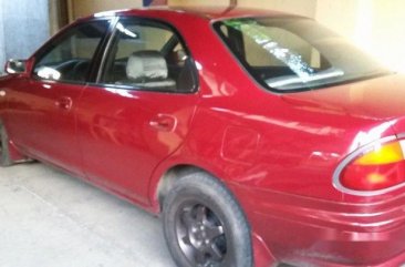 Red Mazda 323 1999 at 100000 km for sale